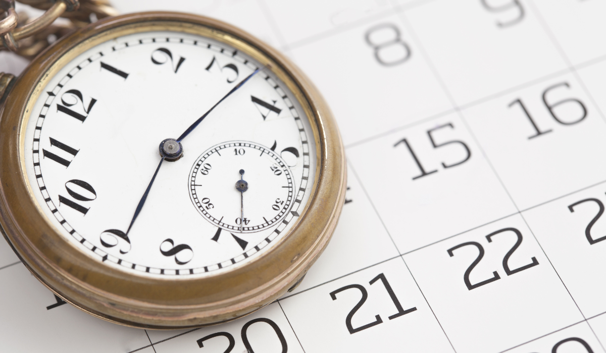 カレンダーの上に置かれた懐中時計のクローズアップ

